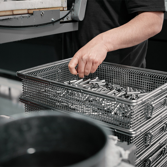 Close up of hand in a pot of metal parts