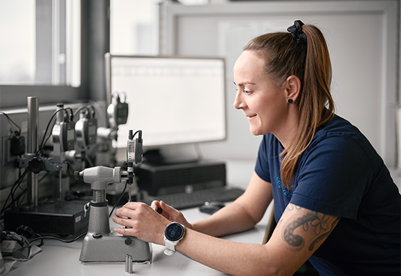 Employee inspecting metal part